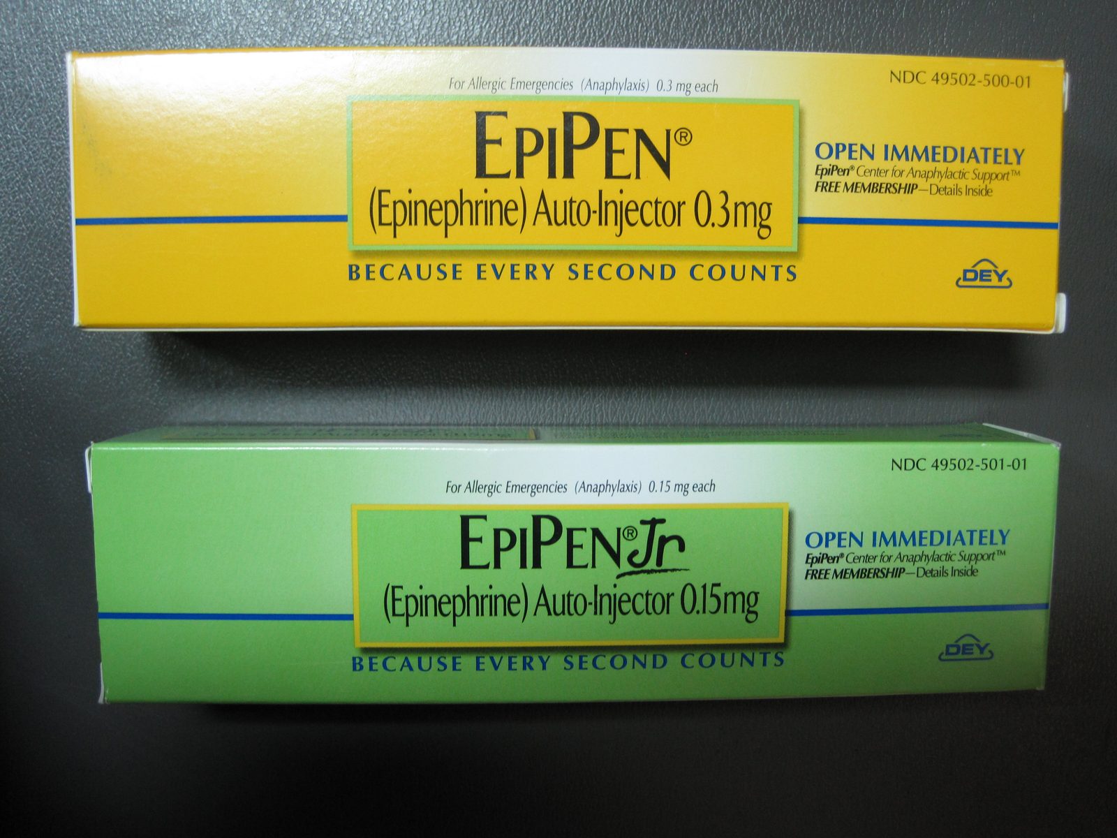 Two boxed epinephrine auto-injector products, EpiPen and EpiPen Jr, photographed on a dark surface.