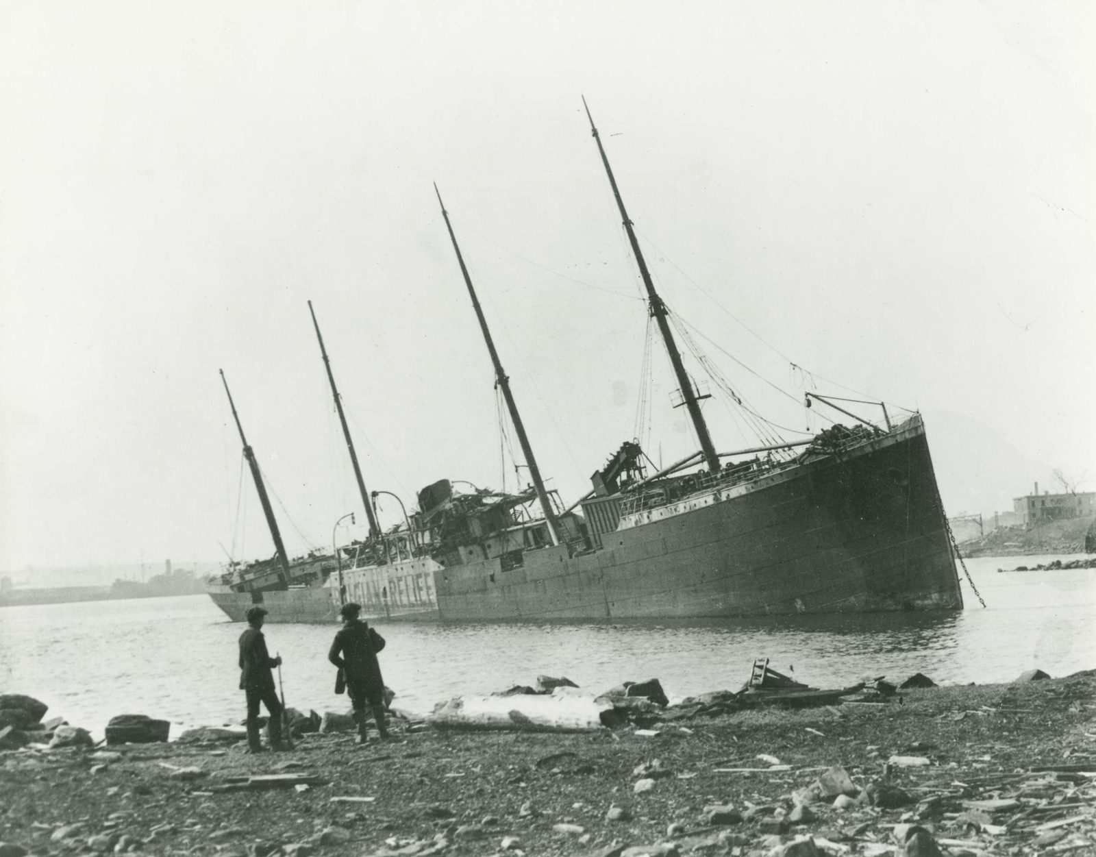 The Imo stranded on the Dartmouth shore after the Halifax Explosion, with damage visible along the waterfront.