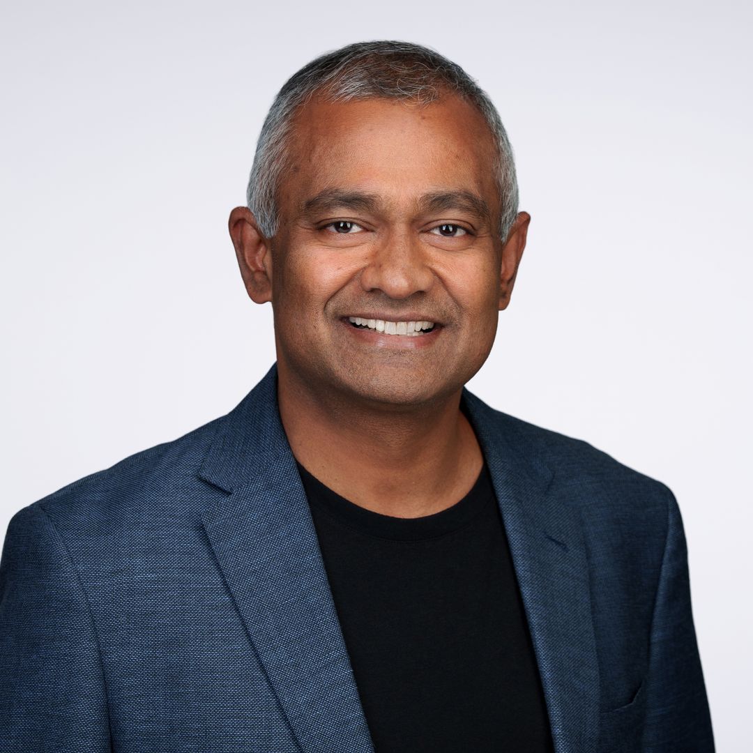 Anand Babu Periasamy smiles in a blue blazer against a light background in a MinIO team portrait.