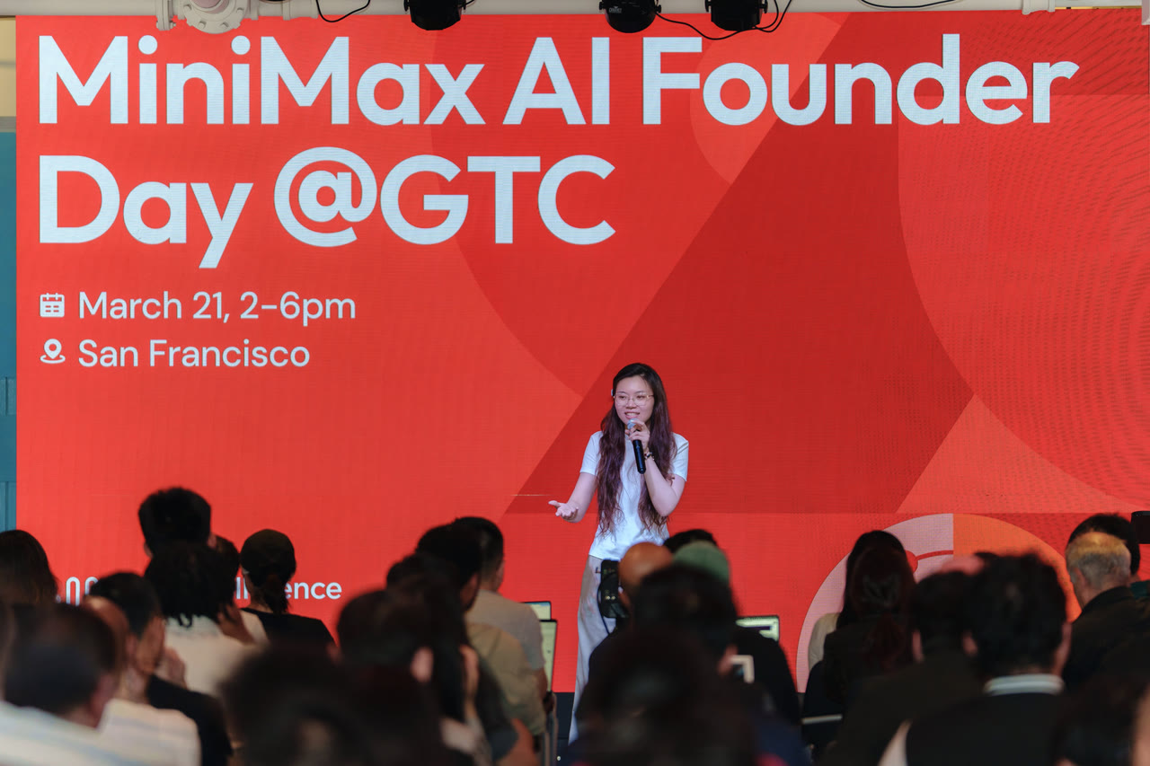 Yeyi Yun 在旧金山 GTC 的 MiniMax AI Founder Day 活动现场台上发言，背后是一整面红色大屏。