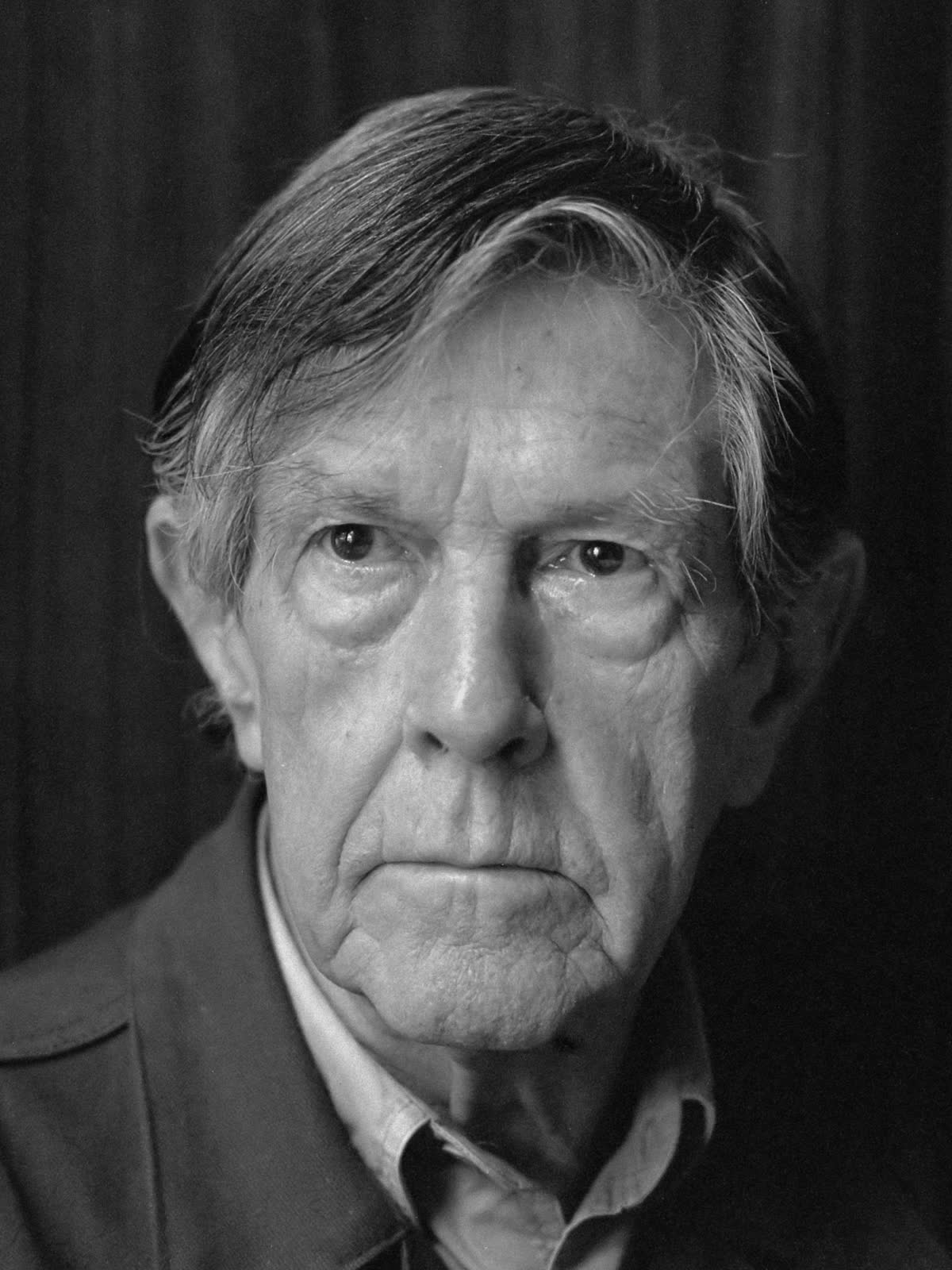 Black-and-white 1988 photographic portrait of John Cage looking toward the camera.