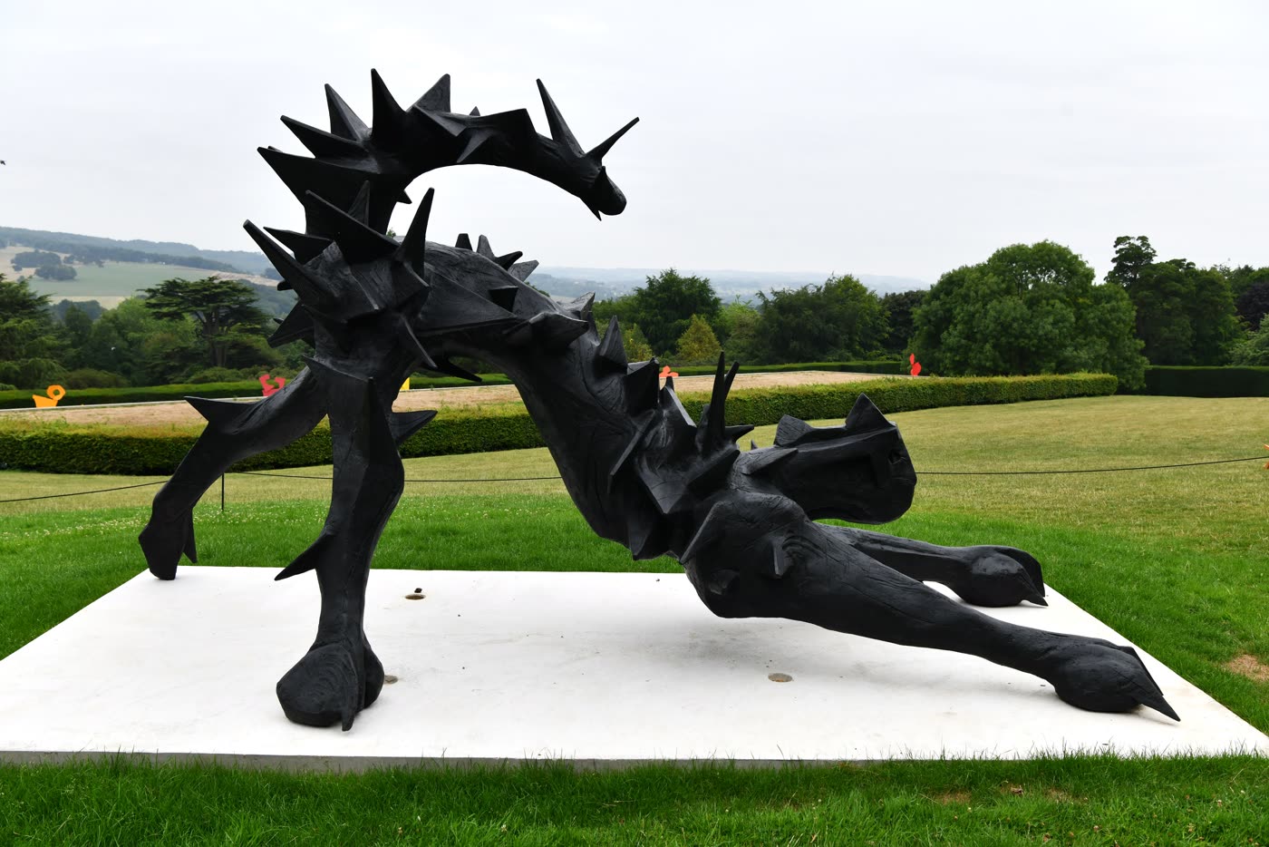 William Kentridge's sculpture Stroke stands outdoors at Yorkshire Sculpture Park, its dark cut-out form rising above grass with trees behind it.
