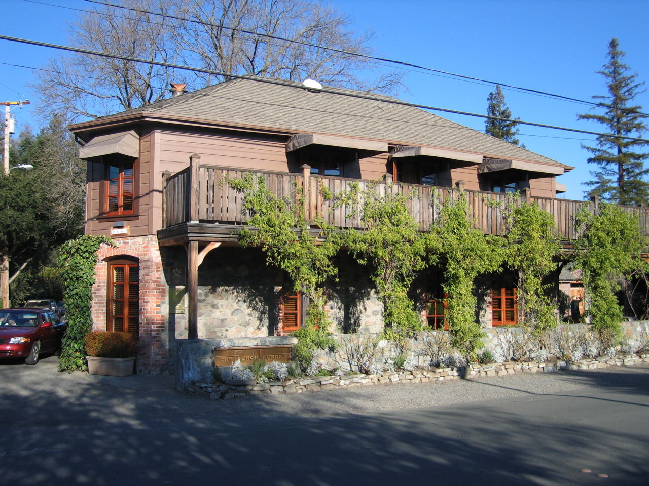 The vine-covered stone exterior of The French Laundry restaurant in Yountville, California, photographed from the street.