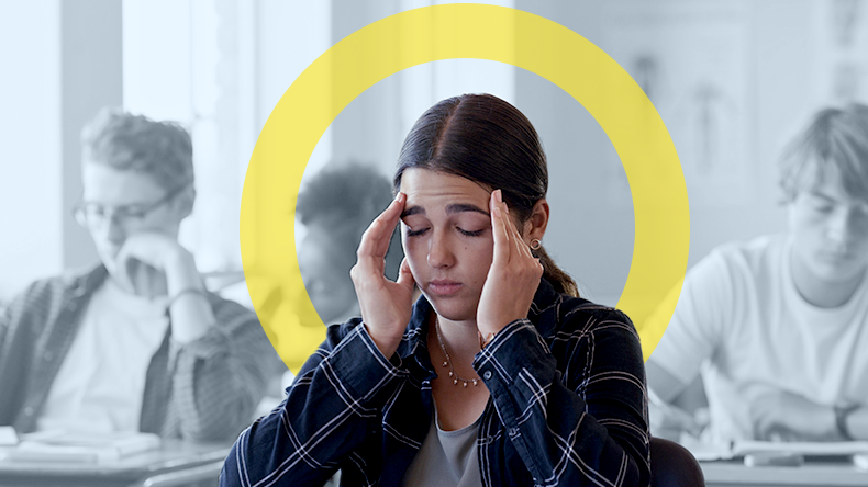 Photograph of a young woman holding both sides of her head as if in pain.