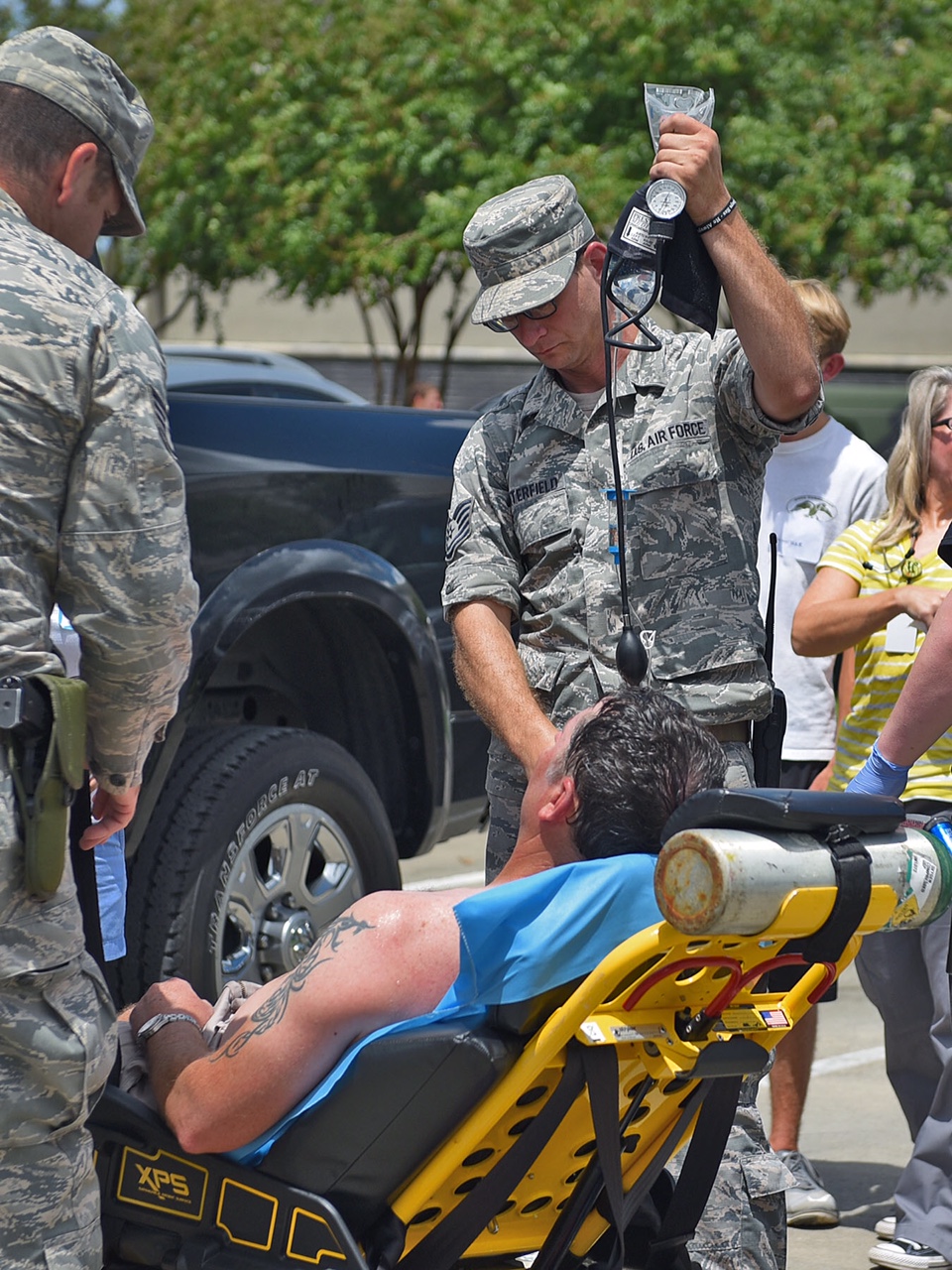 A Louisiana Air National Guard responder treats an overheated evacuee at a Baton Rouge flood shelter.