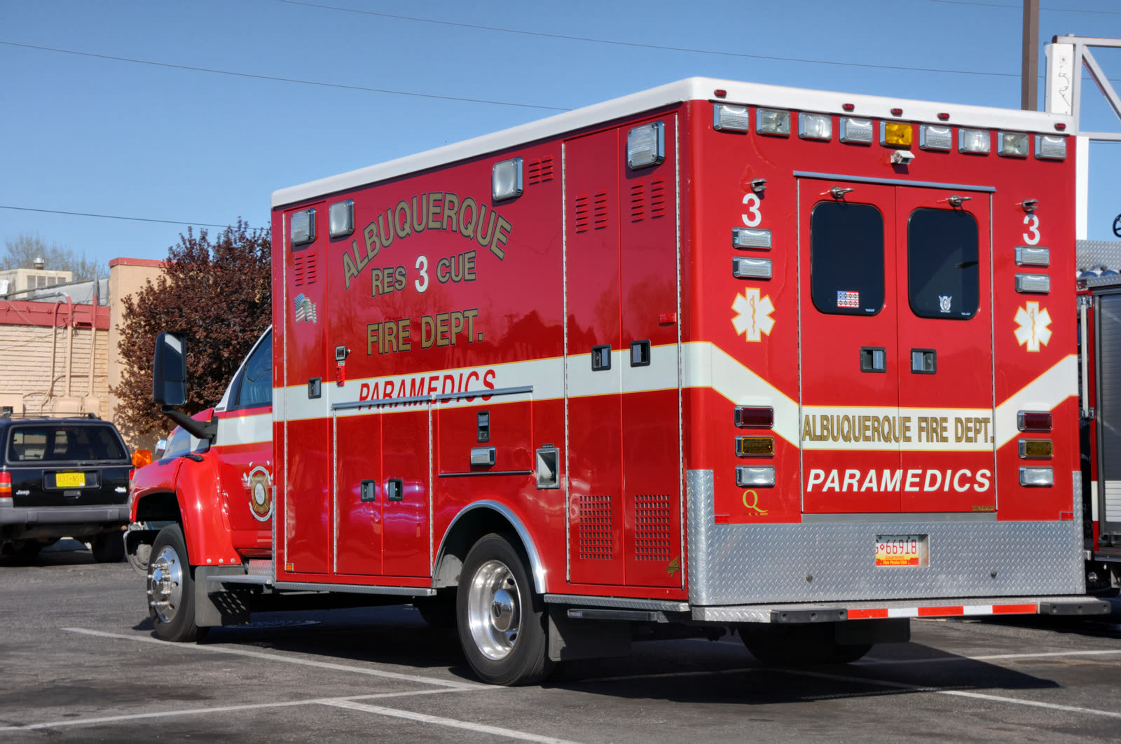 Paramedics inside an ambulance preparing a patient transport stretcher.