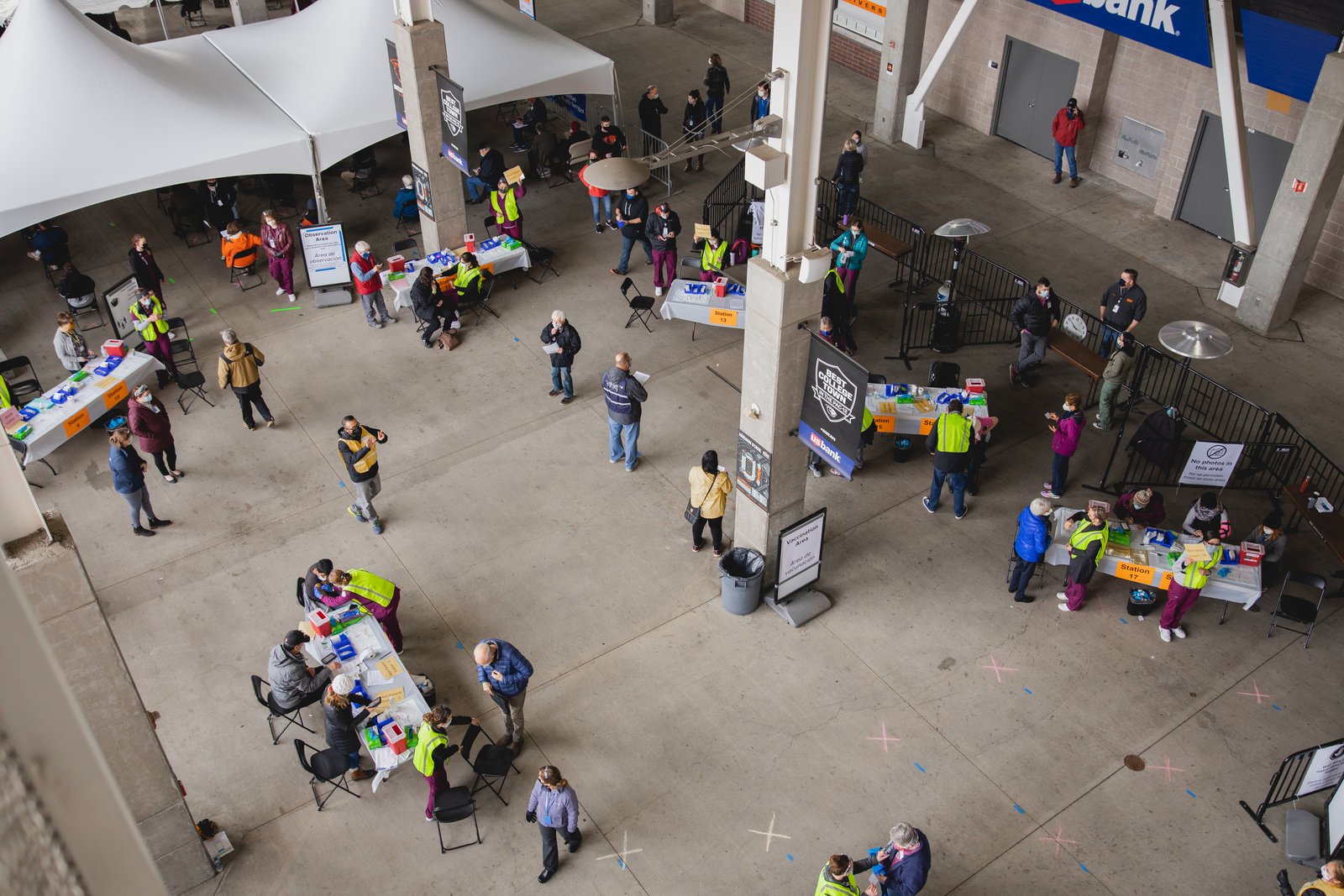 Photograph of masked staff and patients moving through a large COVID-19 mass-vaccination clinic inside Oregon State University's Reser Stadium.
