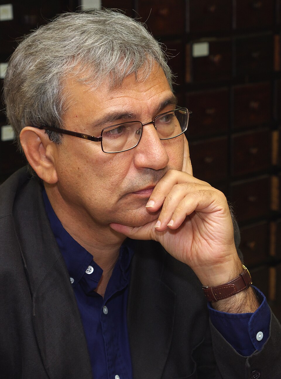 Orhan Pamuk seated at a public event in a 2009 photographic portrait.