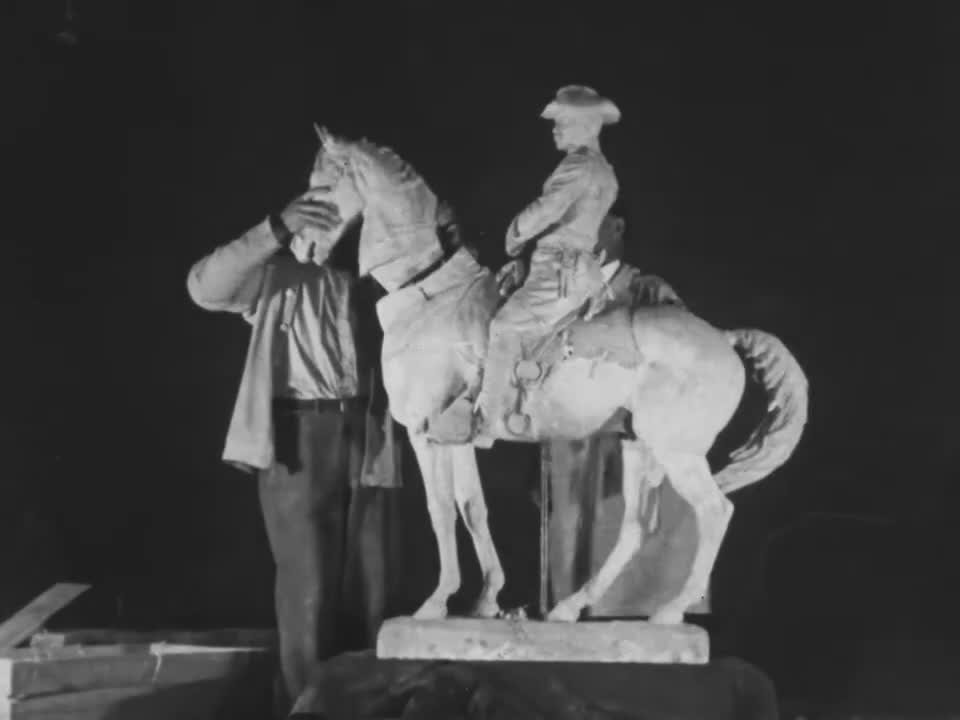 Alexander Phimister Proctor stands beside a plaster model of Theodore Roosevelt on horseback in a frame from the 1922 film The Making of a Bronze Statue.
