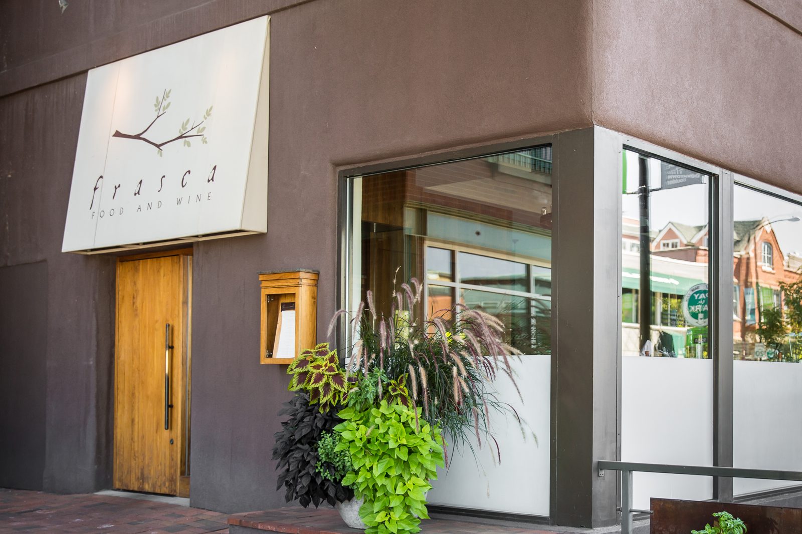 Frasca Food and Wine's exterior on Pearl Street in Boulder, with a pale facade, awning, and low evening light.