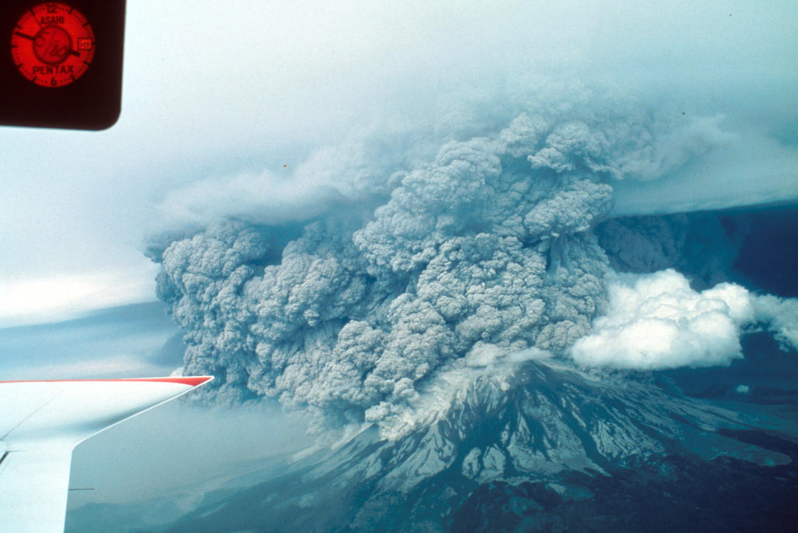 Aerial USGS photograph of Mount St. Helens erupting on May 18, 1980, with ash and pyroclastic density currents spilling from the crater.