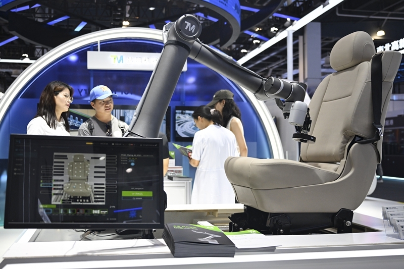 Visitors inspect a robotic quality-checking system at the 2025 World AI Conference exhibition in Shanghai.