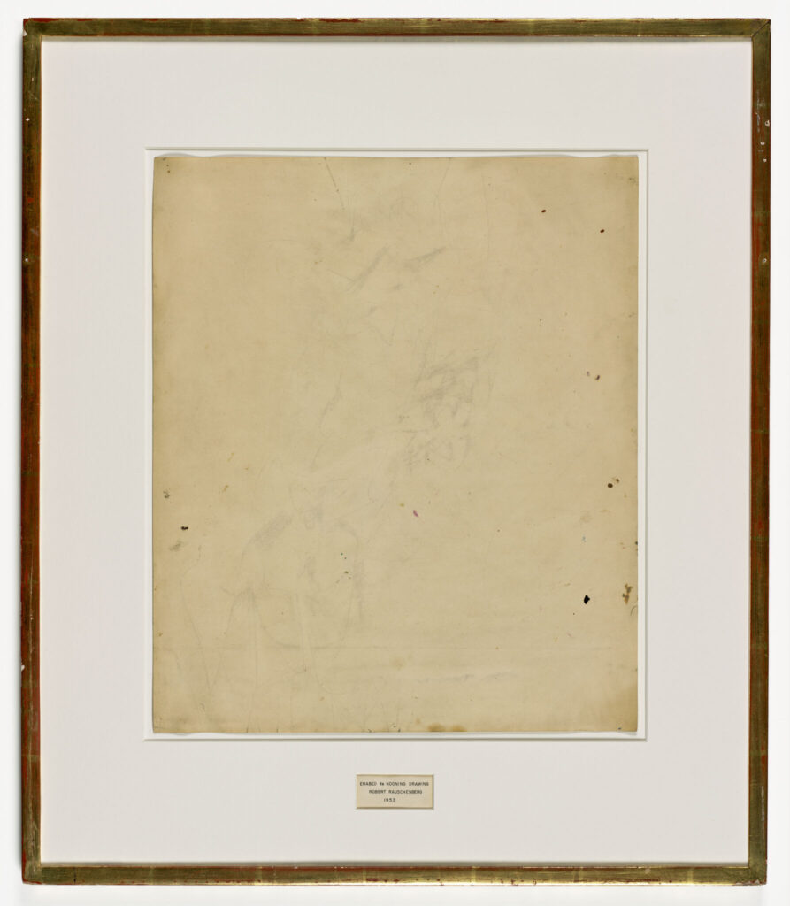 Photographic reproduction of Robert Rauschenberg's Erased de Kooning Drawing, showing a pale sheet with faint traces, a handwritten label, and a simple gilded frame.