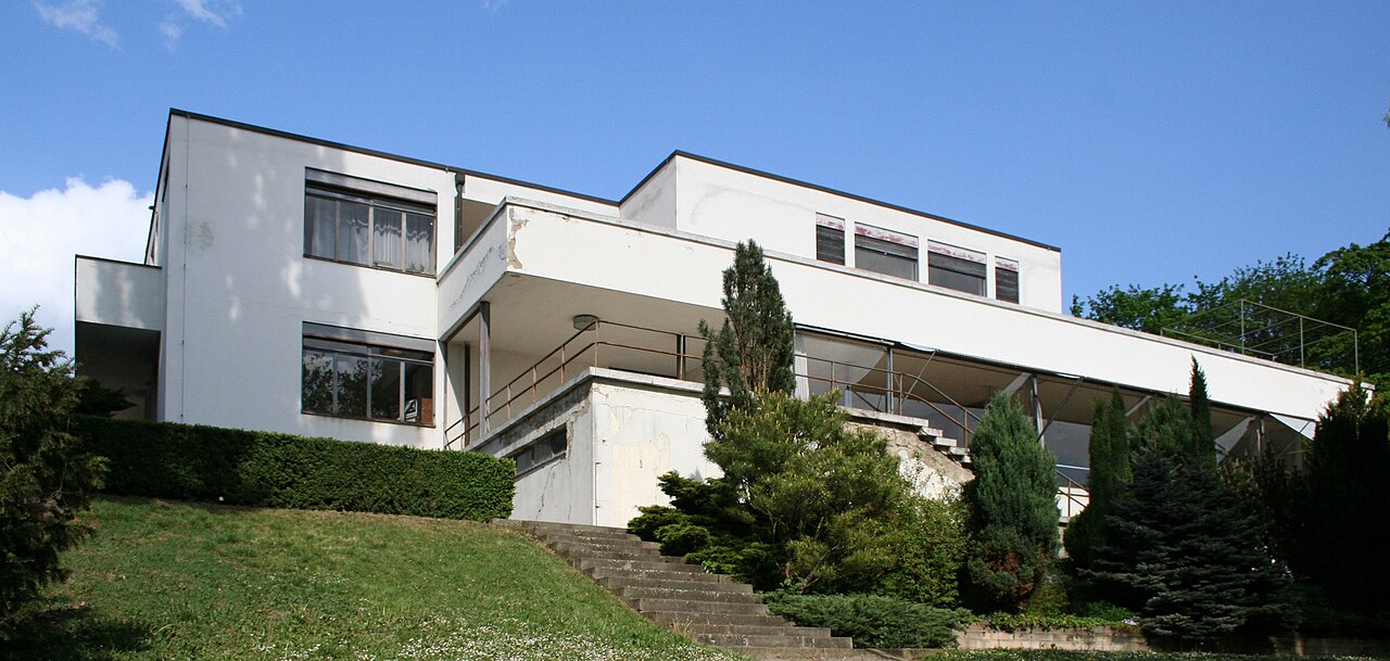 Villa Tugendhat seen from the garden in Brno, with its white modernist volumes set into the slope above the city.