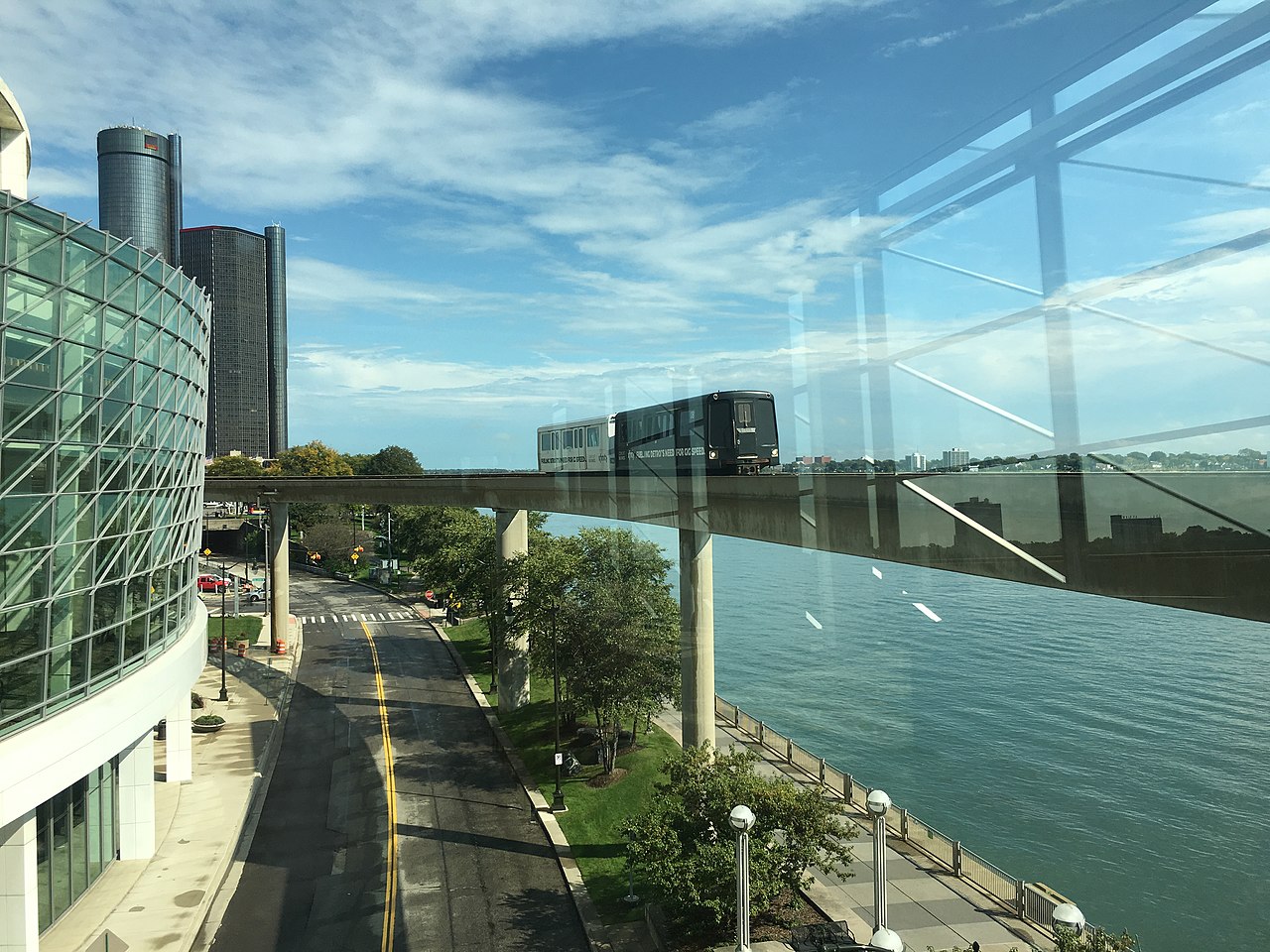 一列 Detroit People Mover 列车从会议中心附近驶过，背景是 Renaissance Center。
