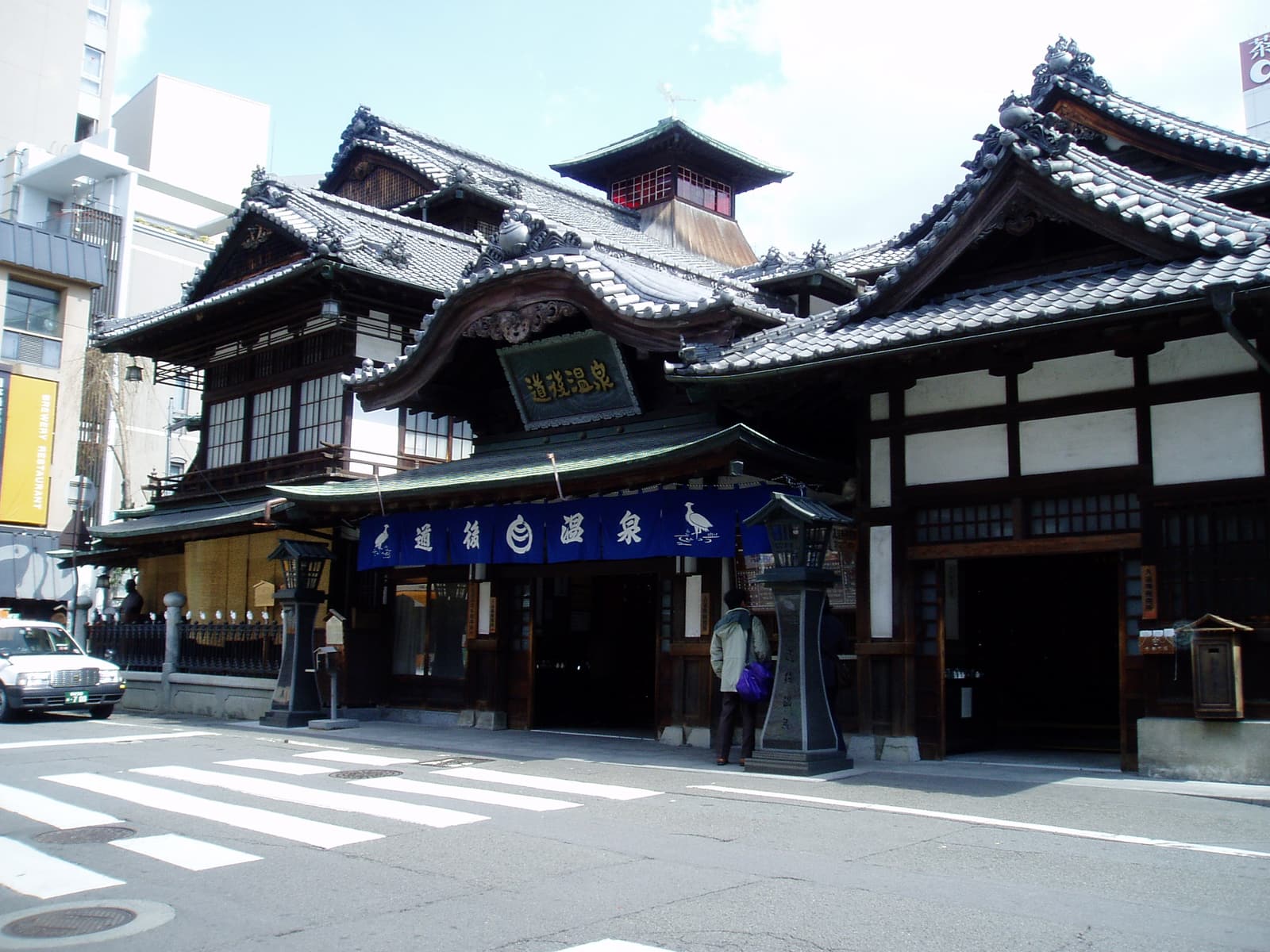 The wooden Dogo Onsen Honkan bathhouse in Matsuyama, photographed from the street.