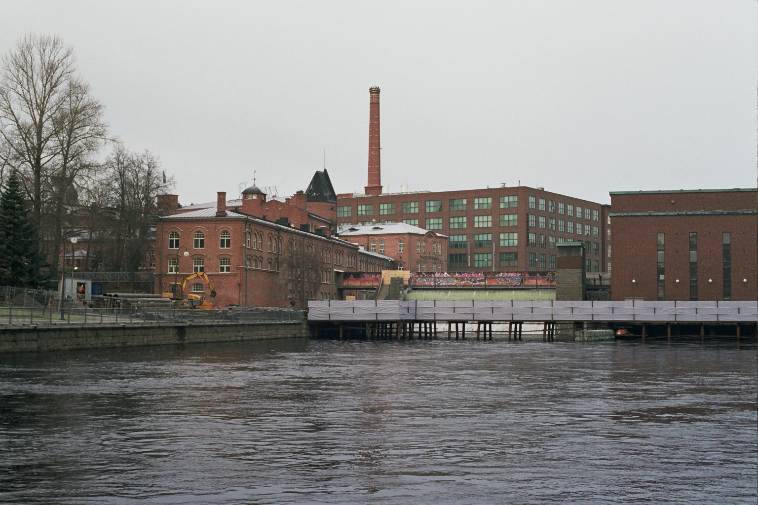 坦佩雷市中心，工业红砖建筑沿 Tammerkoski 急流排列，水流后方可见 Finlayson 工厂建筑。