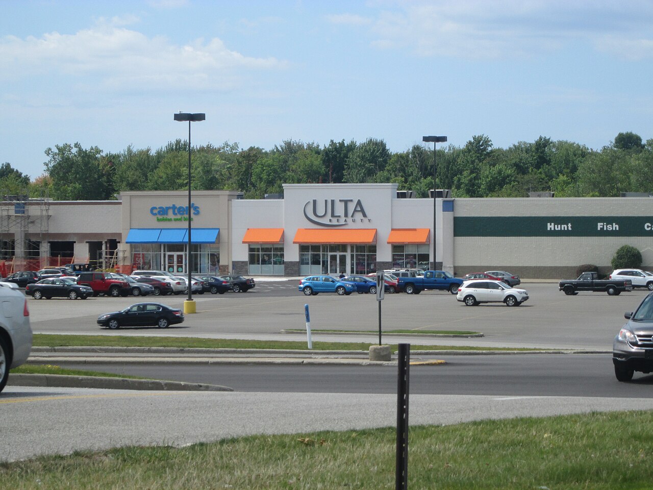 An Ulta Beauty storefront in a suburban shopping center with a parking lot in front.