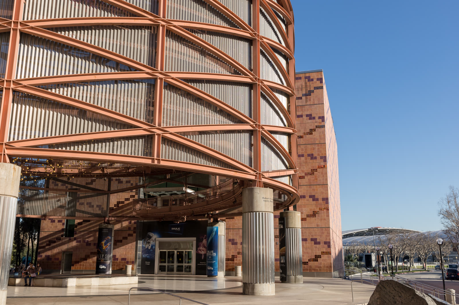Exterior photograph of the Exposition Park IMAX Theater in Los Angeles at dusk.