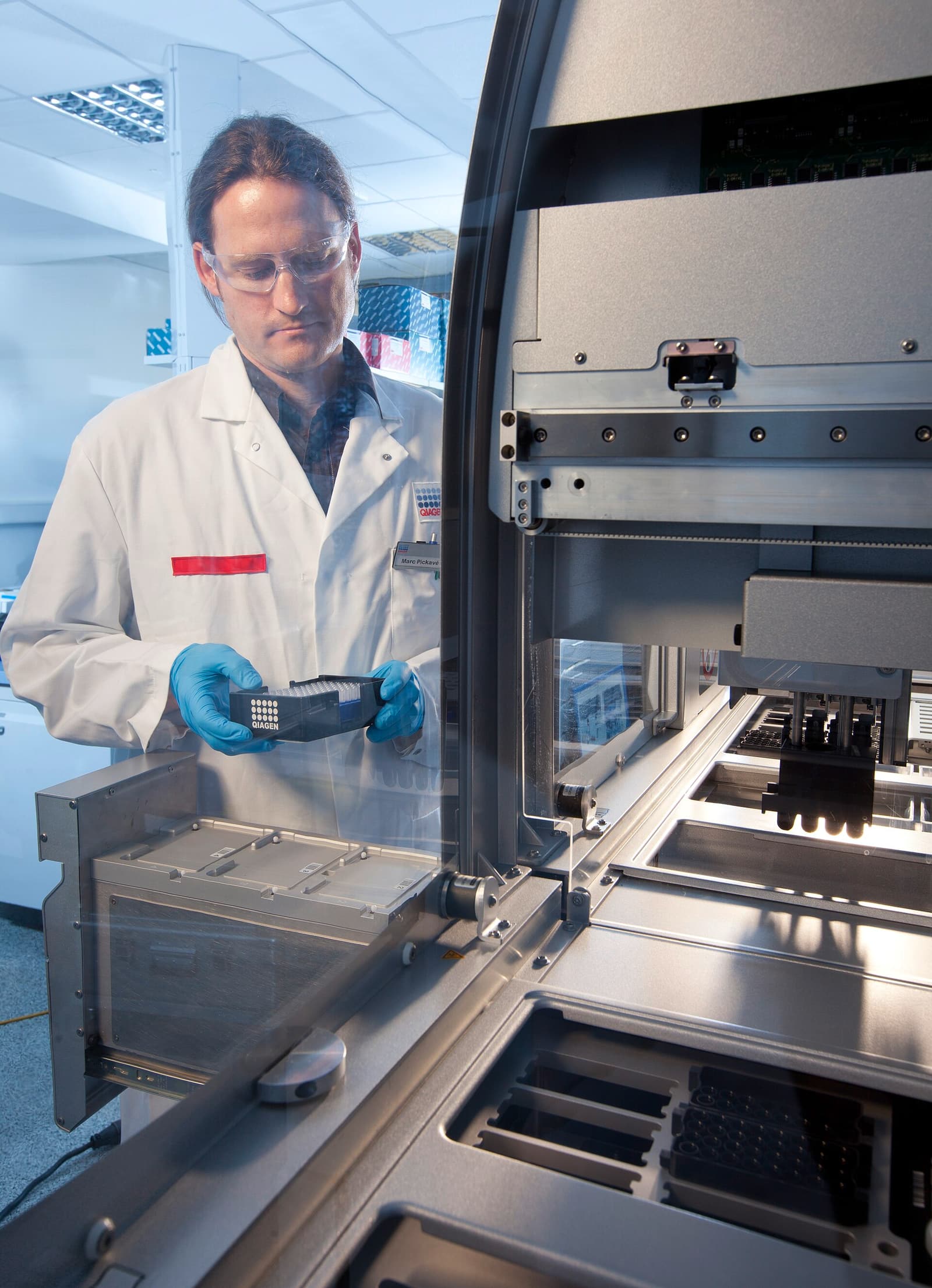 A scientist loads a QIAsymphony molecular diagnostics platform in QIAGEN's Hilden application laboratory.