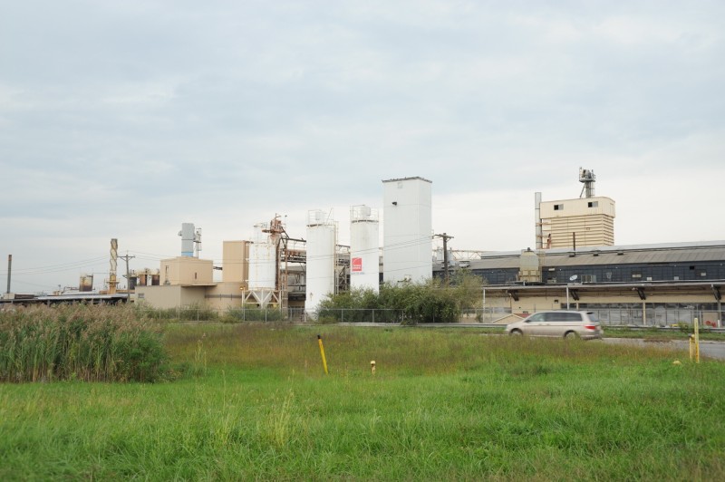 Meadowlands 的一座 Owens Corning 沥青屋面瓦工厂，阴天之下可见料仓、厂房和路边草地。