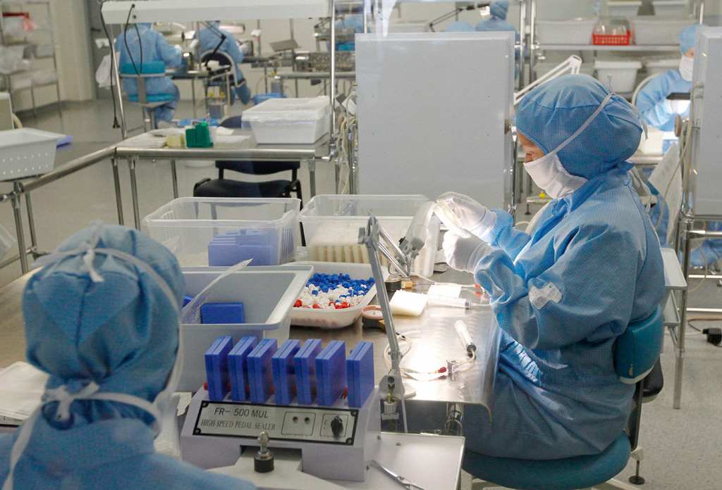 穿防护服的技术人员在血浆生产所用膜过滤设备旁工作。