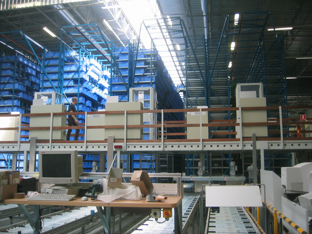 An automatic small-parts warehouse with tall storage racks and an enclosed retrieval aisle.