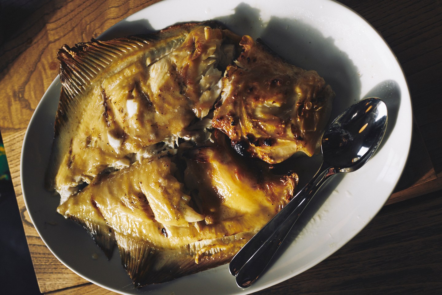 A whole turbot at Brat in London, browned from the grill and served on a metal tray.