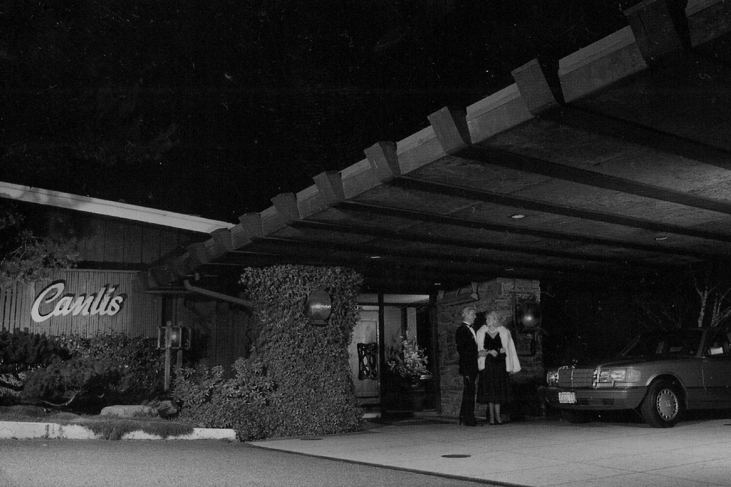 Black-and-white photograph of the Canlis porte-cochere and hillside restaurant exterior in Seattle.