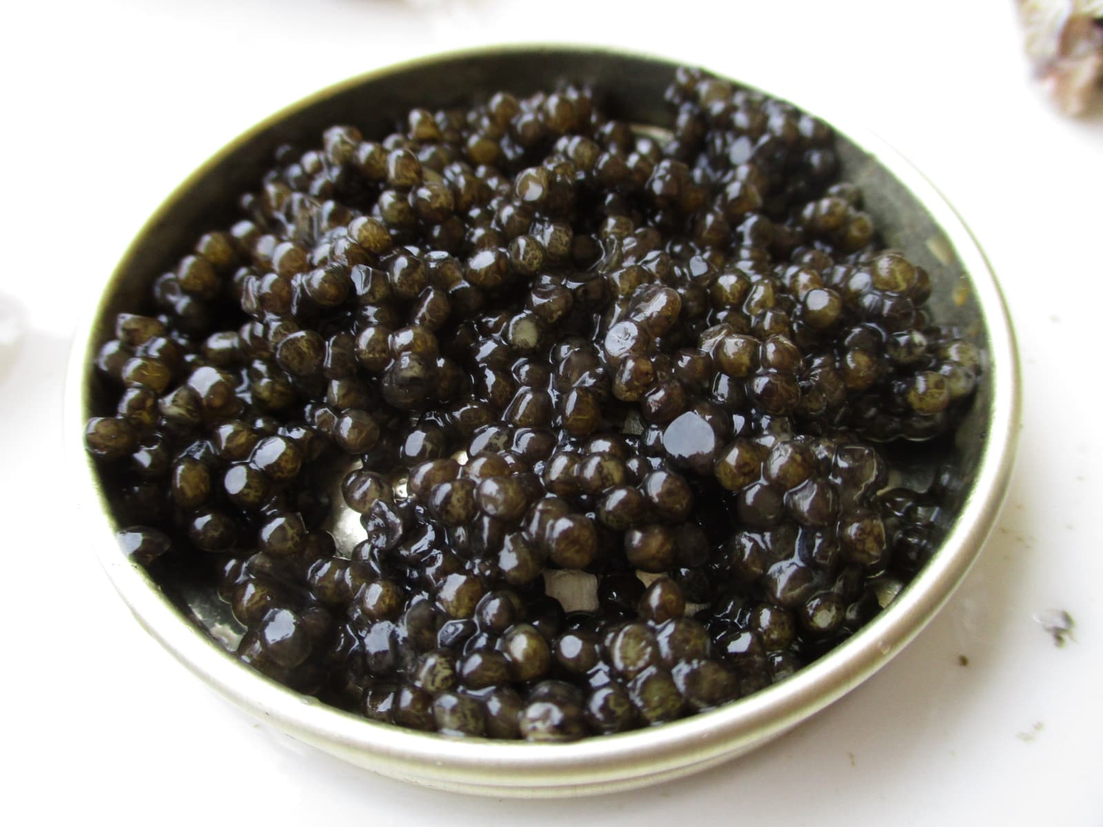 A close photograph of dark caviar piled in a small bowl.
