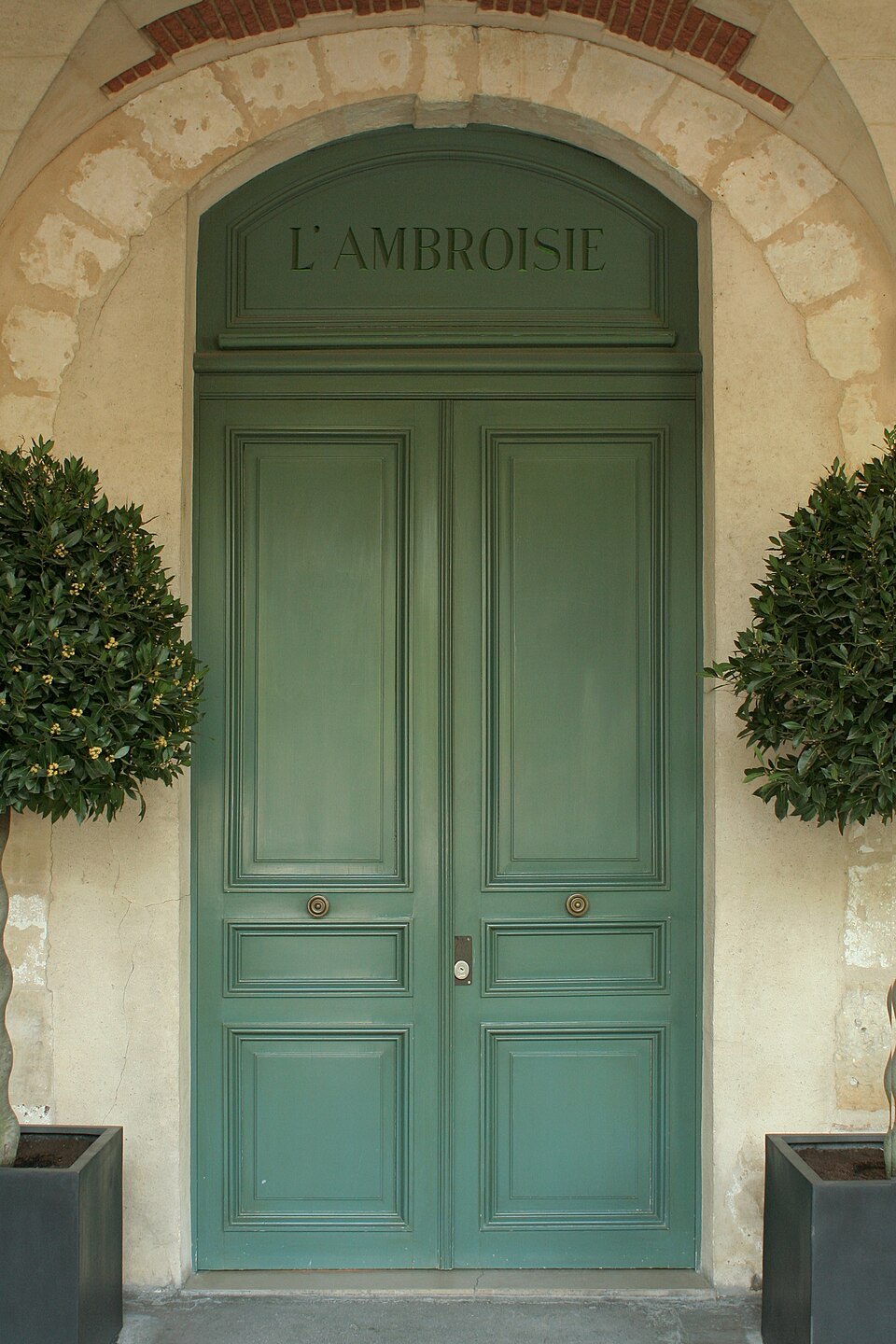 巴黎 Place des Vosges 9 号的绿色门，从拱廊下拍摄；这里是 L'Ambroisie 的地址。