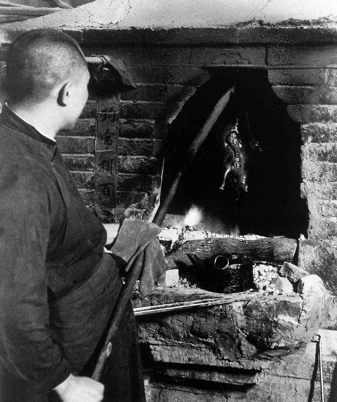 A 1933 archival photograph of ducks roasting in a hanging oven at Quanjude in Beijing.