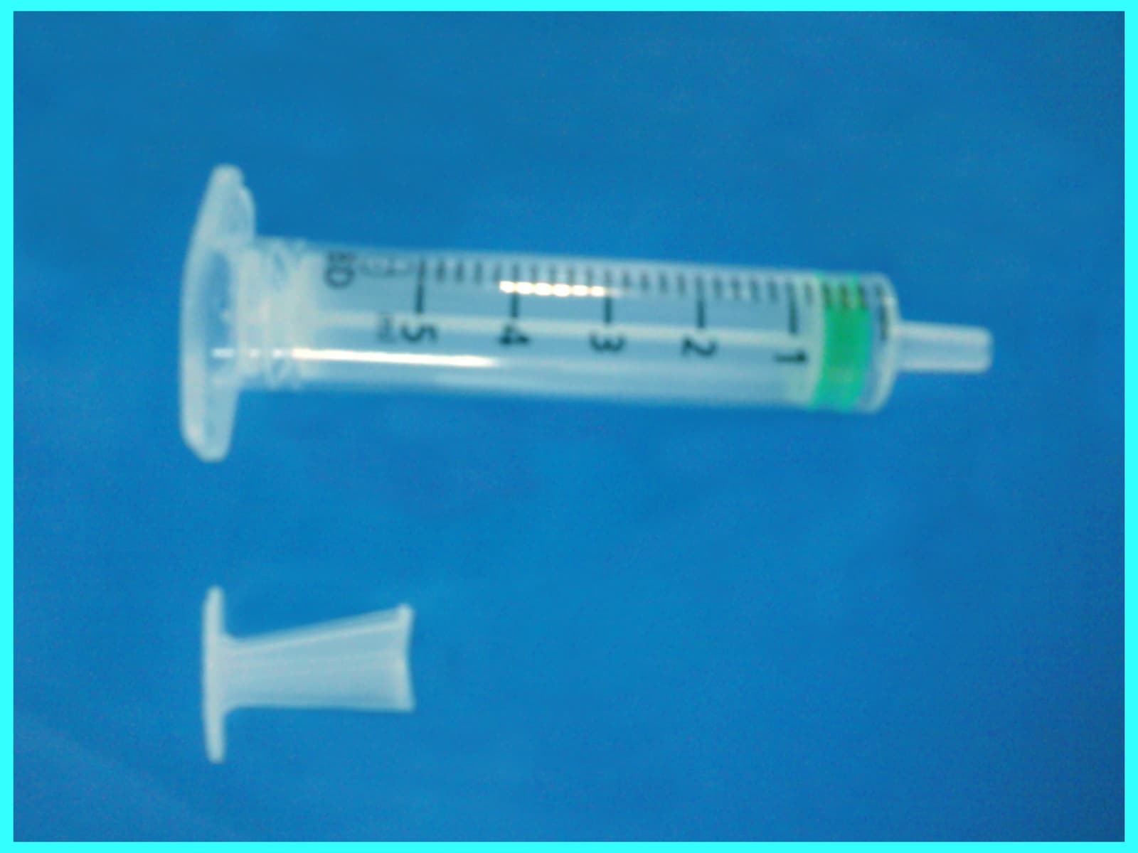 Photograph of a broken auto-disable syringe on a plain surface.