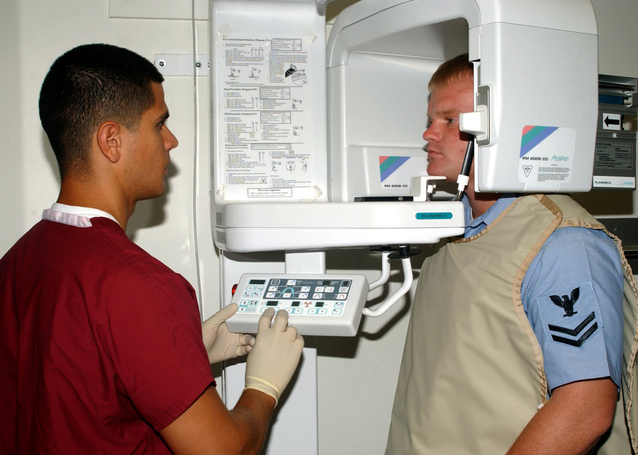 U.S. Navy photograph of a dental technician preparing a patient for dental X-rays.