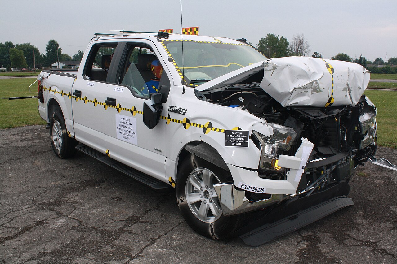 NHTSA frontal crash-test photograph of a 2015 Ford F-150 striking a fixed barrier.