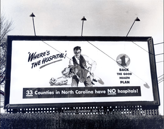 Black-and-white archival photograph of a North Carolina billboard asking where the hospital is in support of the Hill-Burton Act.