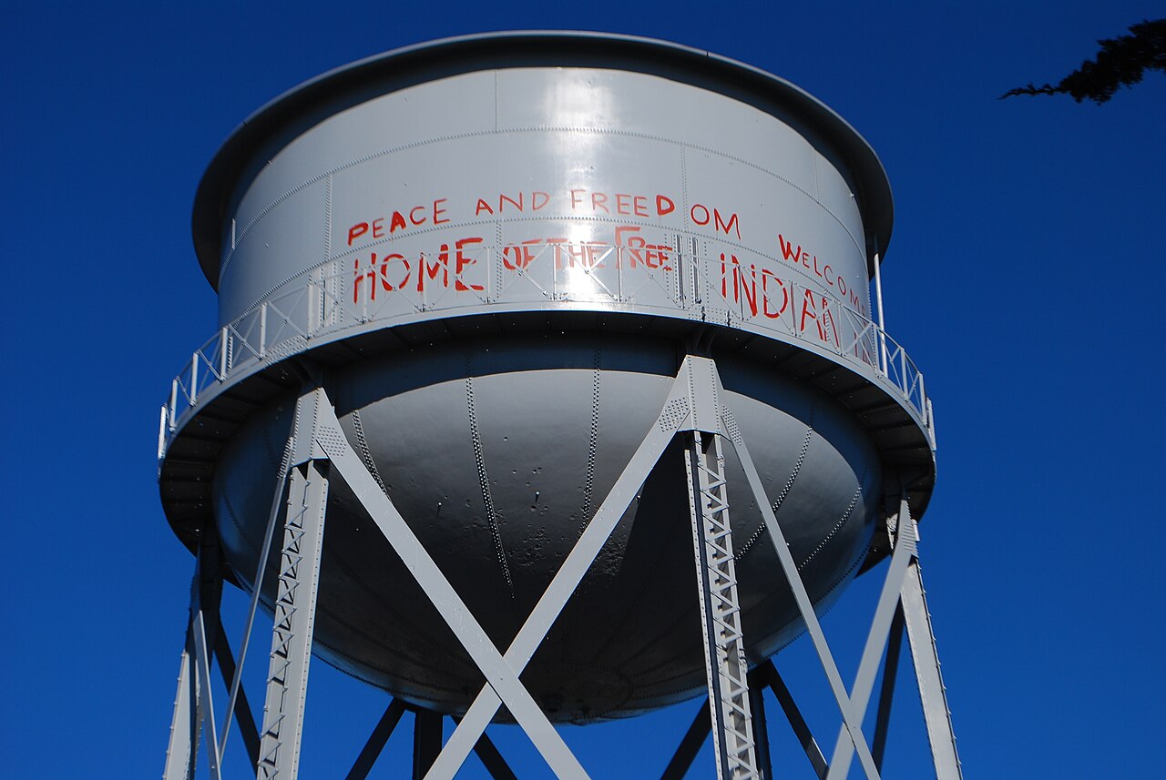 Photograph of Alcatraz Island's water tower with red occupation-era text reading Indian Land.