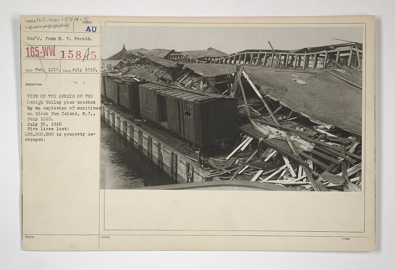 Black-and-white archival photograph of debris from the Lehigh Valley pier after the Black Tom explosion in New York Harbor.