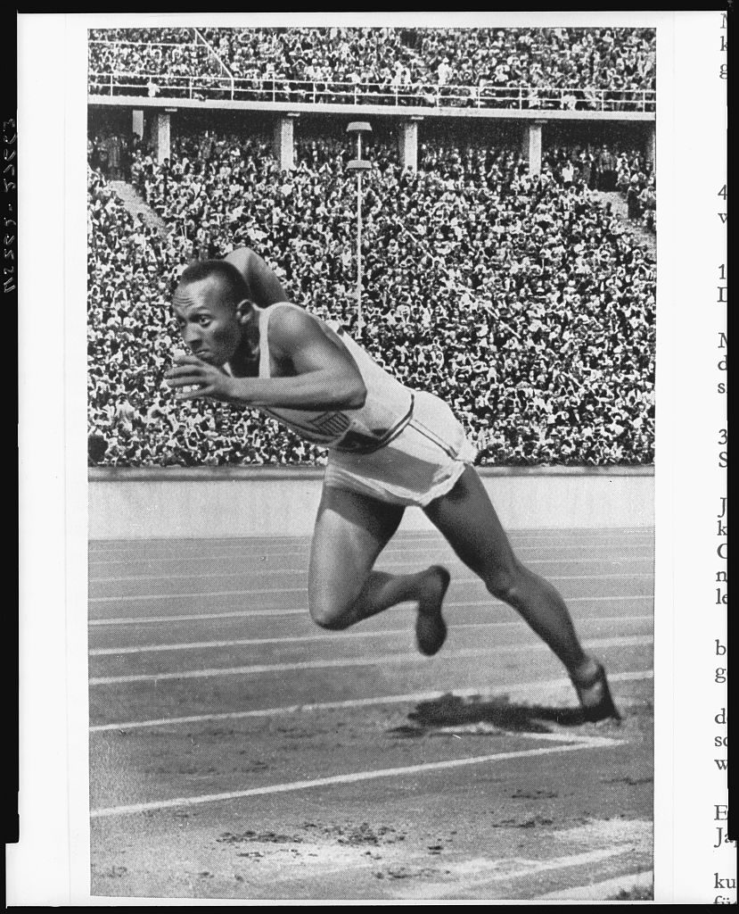 Black-and-white archival photograph of Jesse Owens at the start of his record-breaking 200-meter race at the 1936 Berlin Olympics.