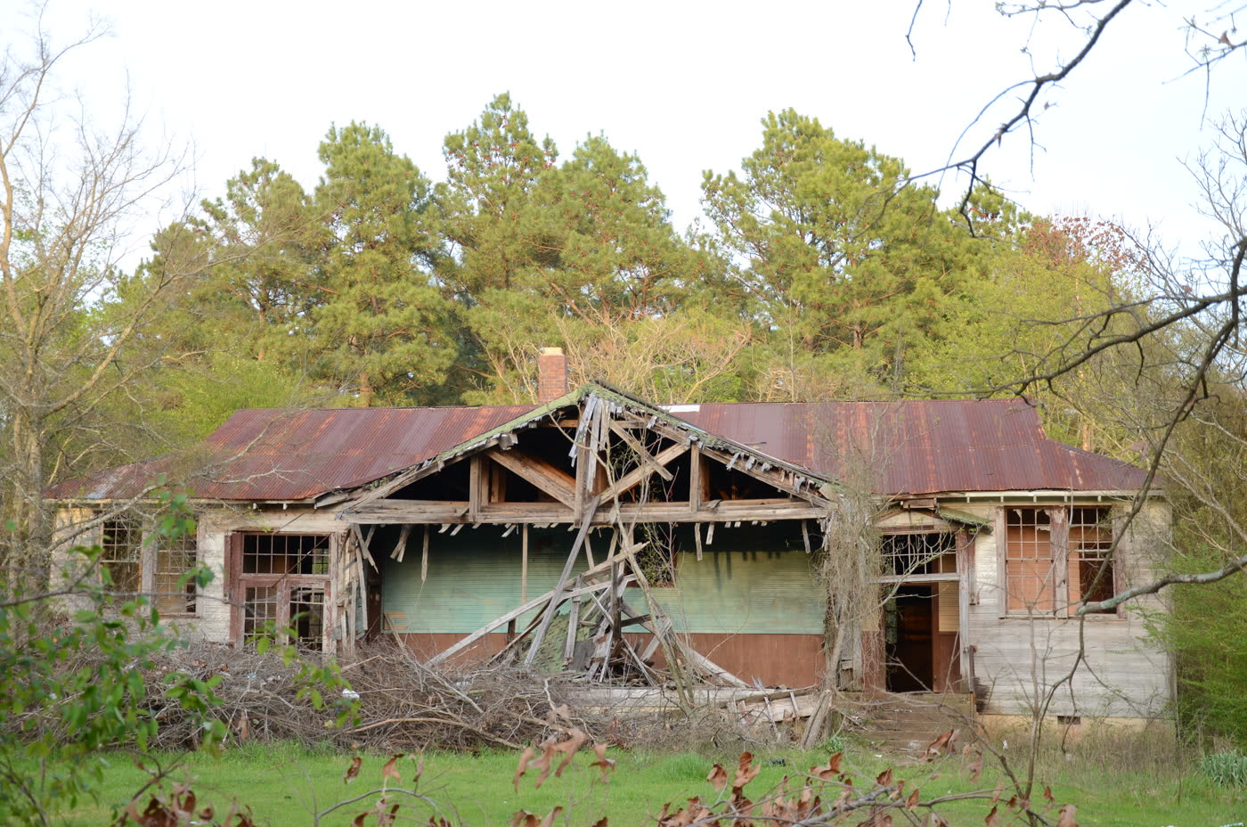 A weathered white wooden Rosenwald school building at Oak Grove, Arkansas, photographed from the front with trees and grass around it.
