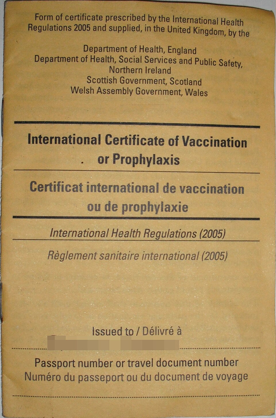 Photograph of an international yellow fever vaccination certificate page with printed fields and handwritten entries.