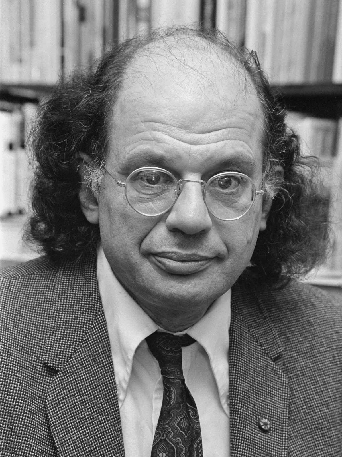 Color photographic portrait of Allen Ginsberg in 1979, looking toward the camera with a full beard and glasses.