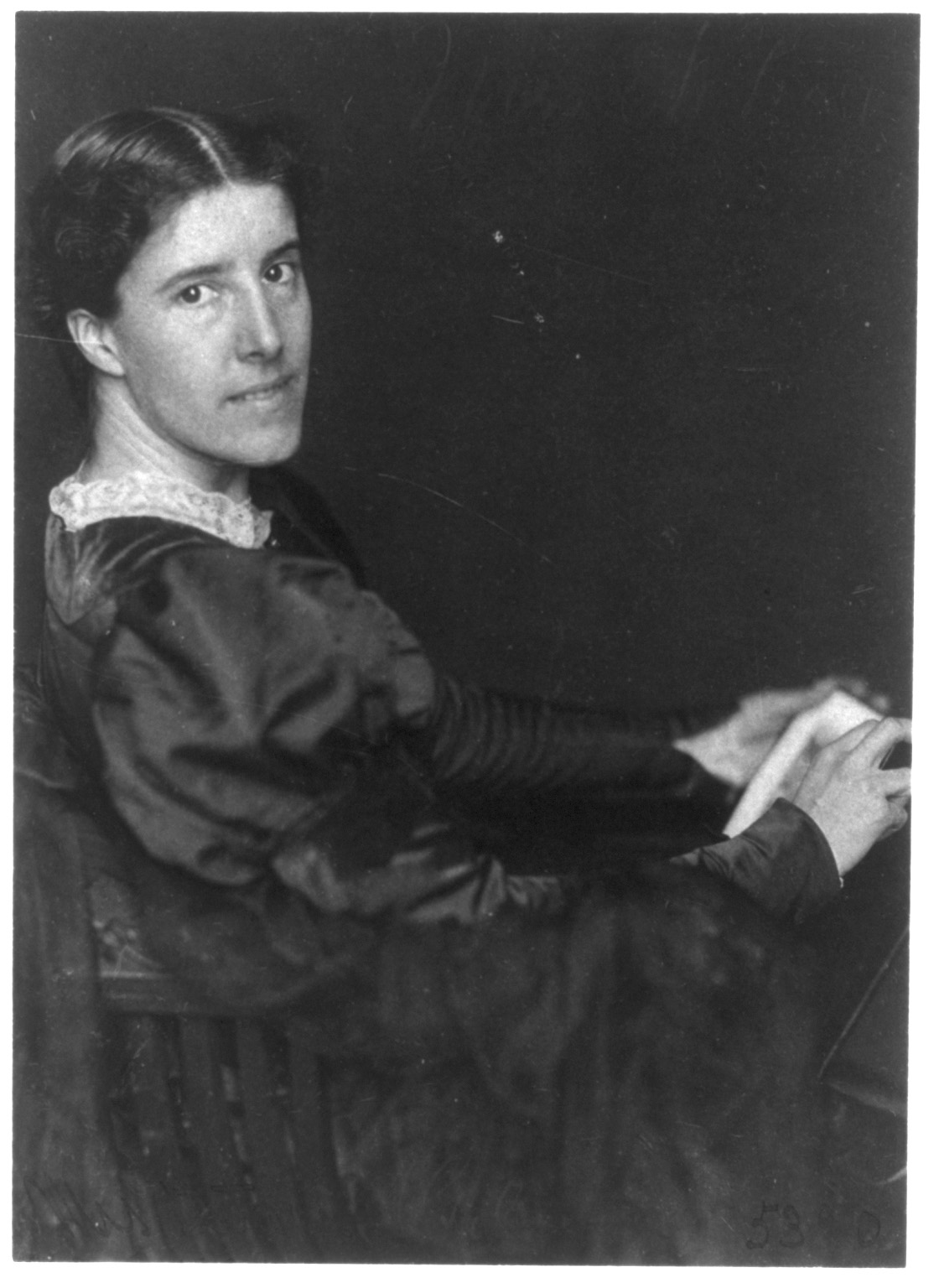 Archival black-and-white portrait photograph of Charlotte Perkins Gilman by Frances Benjamin Johnston, showing Gilman in profile with her head turned toward the camera.
