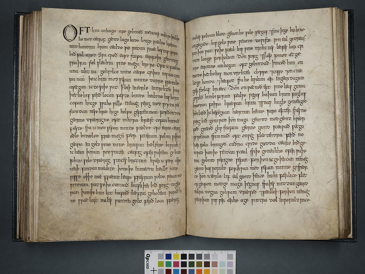 Photograph of the Exeter Book opened to folios 76v and 77r, where The Wanderer begins with a decorated initial on the left-hand page.