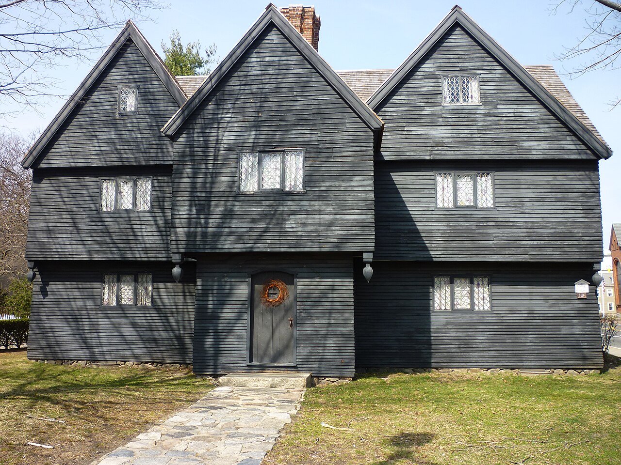 Photograph of the Witch House in Salem, Massachusetts, with dark timber siding, steep gables, and a street-level view.