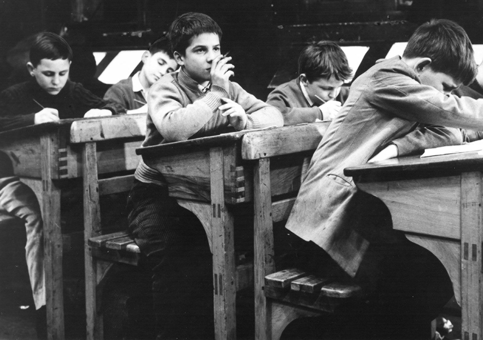 Black-and-white scene from The 400 Blows showing Jean-Pierre Leaud seated among schoolboys in a classroom.