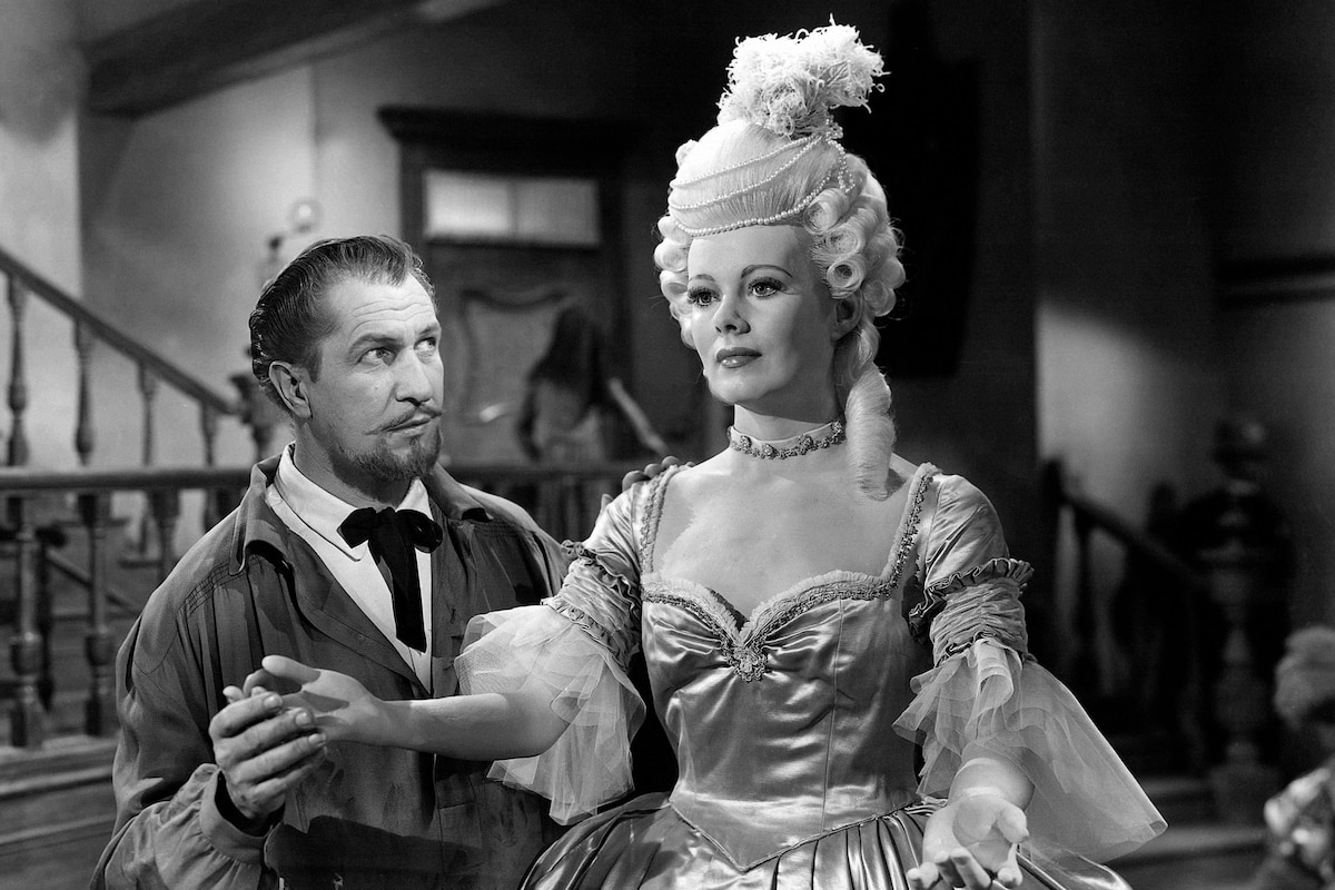 Black-and-white TCM still from House of Wax showing Vincent Price beside a Marie Antoinette wax figure in the museum set.