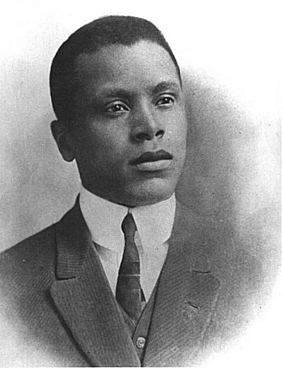 A black-and-white circa 1913 studio portrait of Oscar Micheaux in a suit and tie.