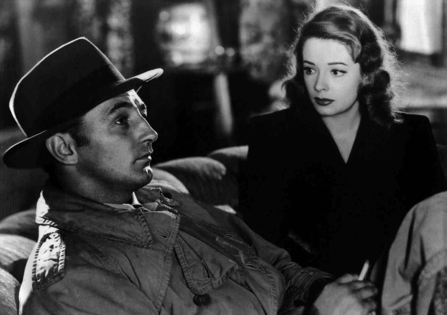 Black-and-white publicity photograph from Out of the Past showing Robert Mitchum and Jane Greer close together in profile.