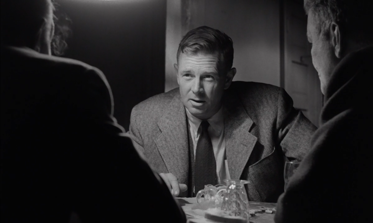 《杀手》预告片的一张黑白截图，Sterling Hayden 饰演的 Johnny Clay 面部紧绷，脸的一部分被光照亮。